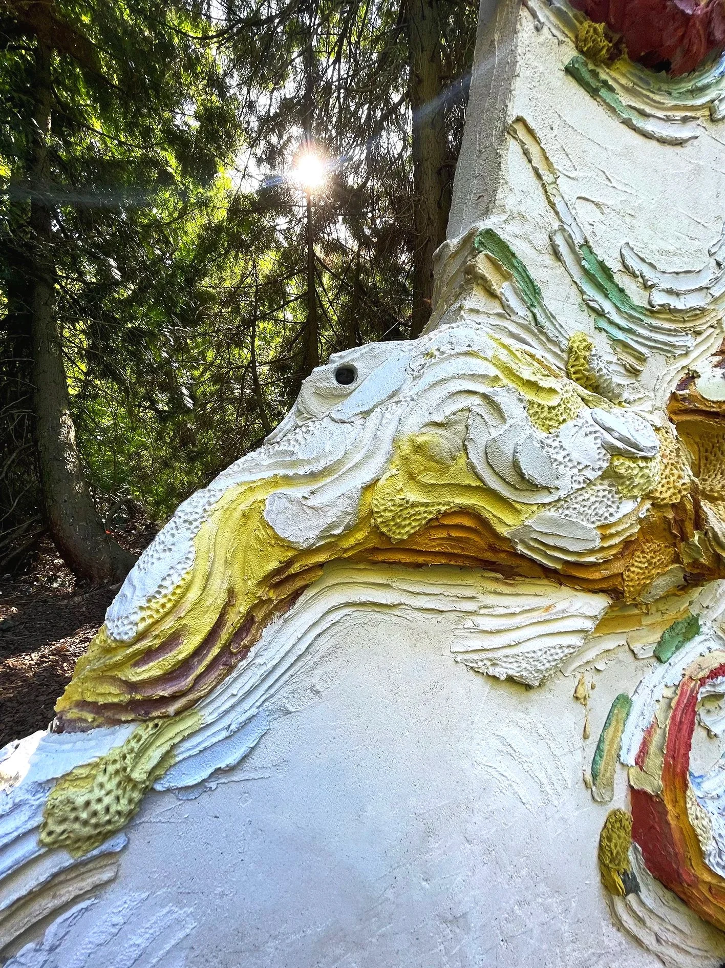 Large scale monumental and colored concrete sculpture depicting an octopus wrapped around an architectural column in an art collection sculpture private park