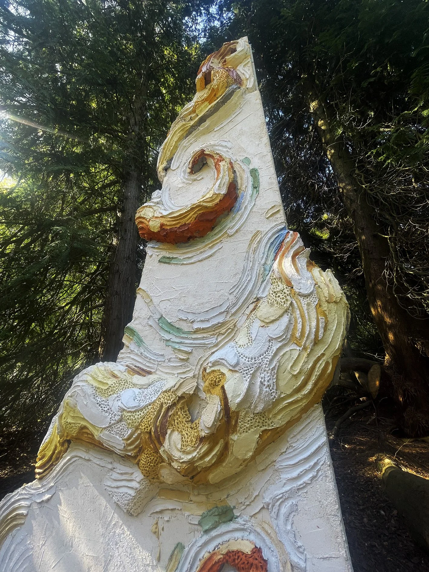 Large scale monumental scultpure made of concrete and colored mortar with extreme organic details depicting a monumental octopus wrapped arouind an architectural colummn  in a private sculpture park owned by a contemporary art collector and a museum