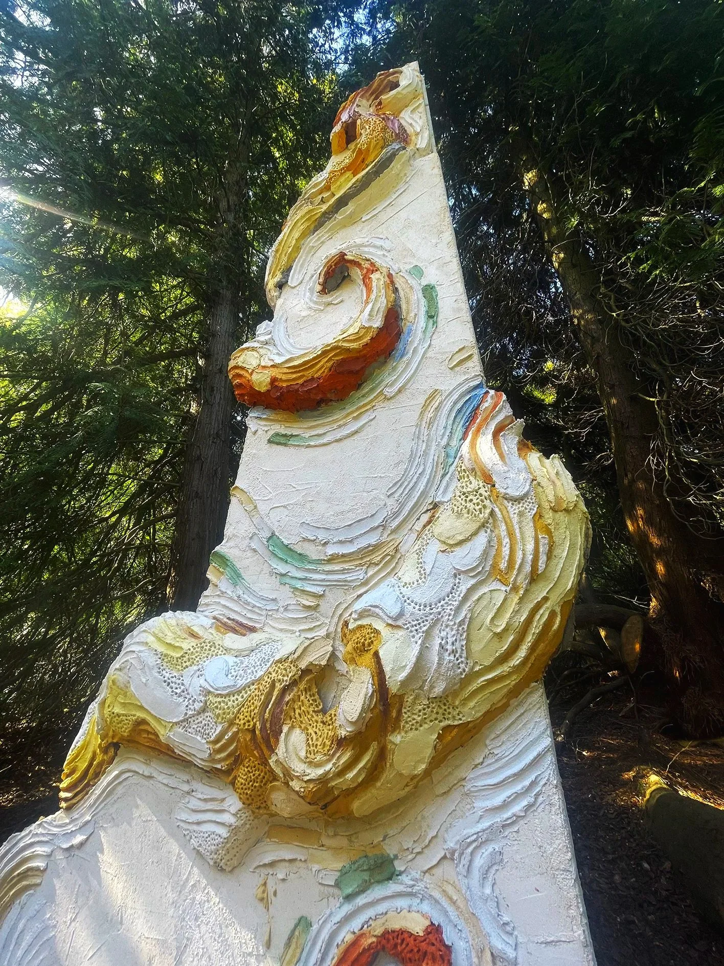Large scale monumental and colored concrete sculpture depicting an octopus wrapped around an architectural column in an art collection sculpture private park