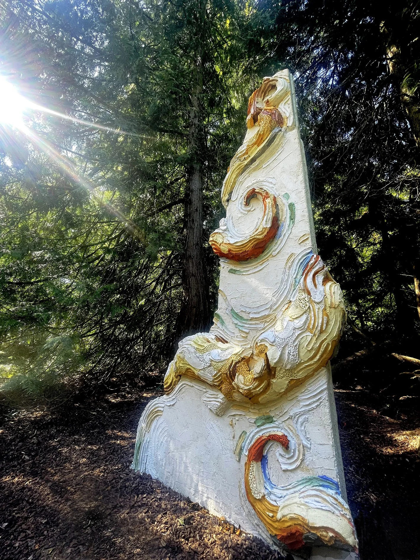 Large scale monumental scultpure made of concrete and colored mortar with extreme organic details depicting a monumental octopus wrapped arouind an architectural colummn  in a private sculpture park owned by a contemporary art collector and a museum