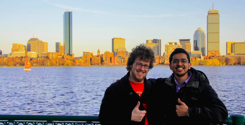 Jason and Muhammed at MIT with the Boston skyline in the background.