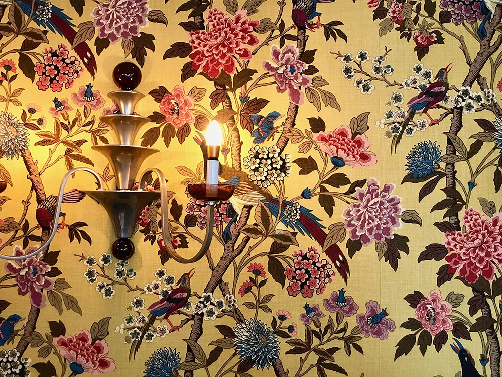 Bold, floral wallpaper adorns the Dining Room at Ockenden Manor, Cuckfield