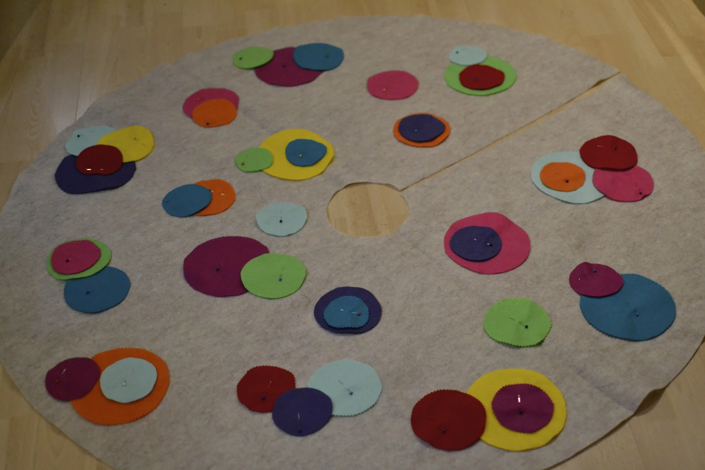 i used an oatmeal felt for the base and actually just used my old tree skirt to trace the circle. this is a 48" diameter circle so, purchasing 1 1/4 yards of felt would do the trick. (this skirt turned out to be pretty large. you could definitely do with using 1 yard of fabric and making the skirt 36" in diameter.) then i used 3 sizes of cups to trace circles on sheets of various felt colors. i cut some of the circles out with regular scissors and others with pinking shears to provide different textures. 