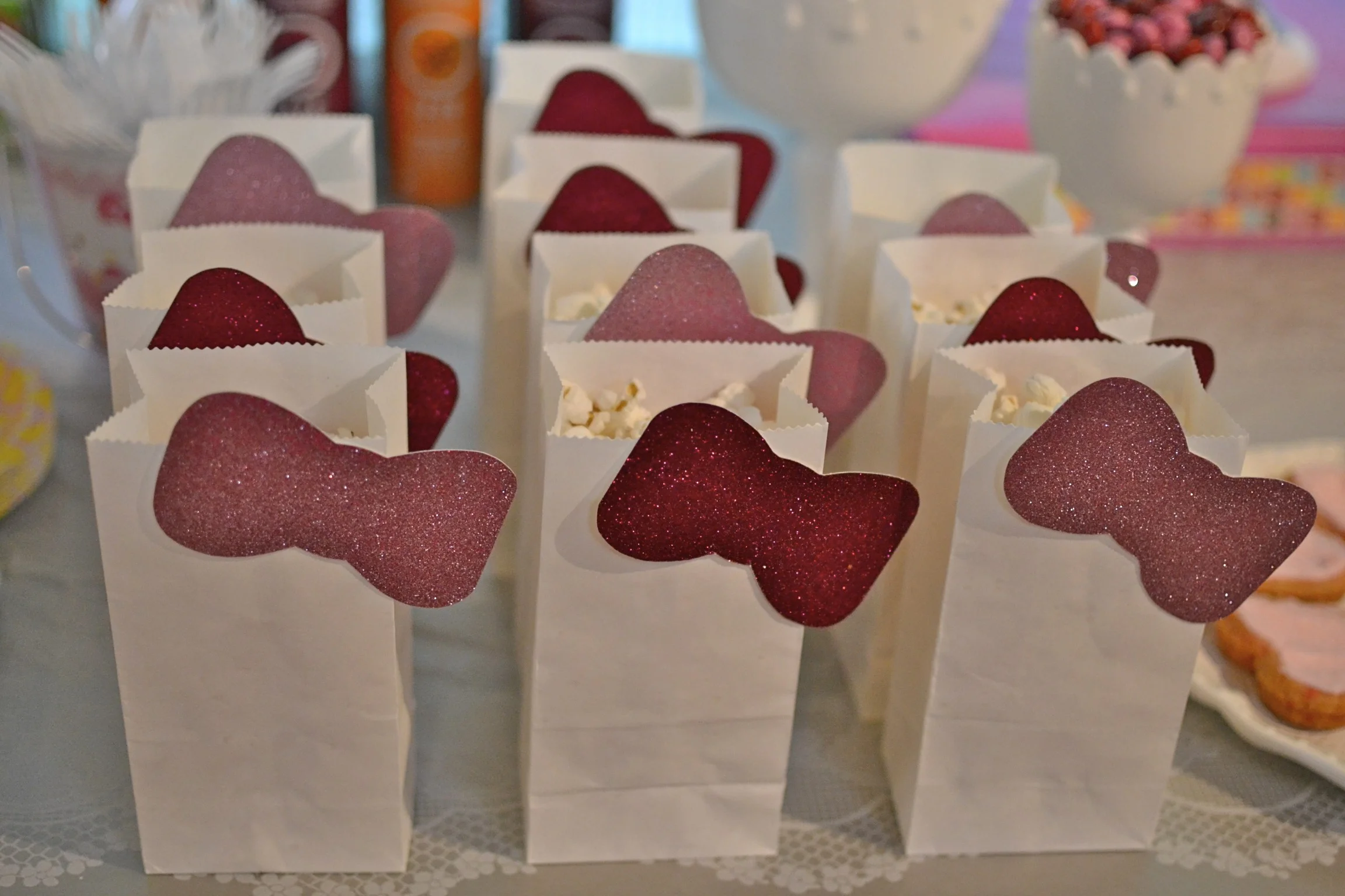 i cut out glittery hello kitty bows and double stick taped them to simple little white bags, to hold salted popcorn