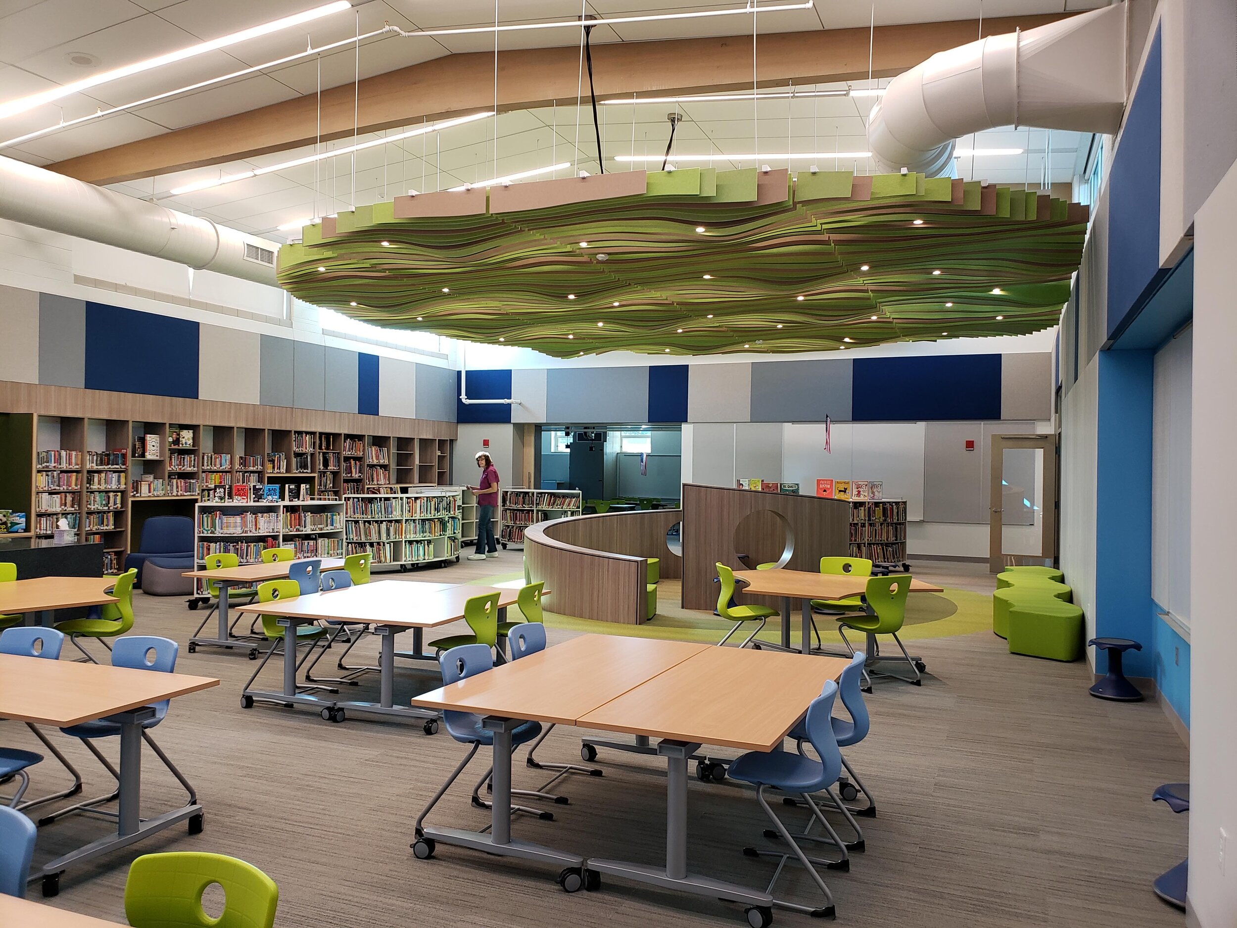 Media Center Interior The former multipurpose room was repurposed into a bright and inviting media center. The highlight is the central reading nook and its decorative ceiling baffles, which were designed to abstractly evoke the feeling of reading b…
