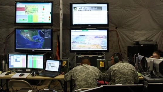 The Command Post of the Future's typical setup: lots of connected visualizations spread out across lots of screens. 