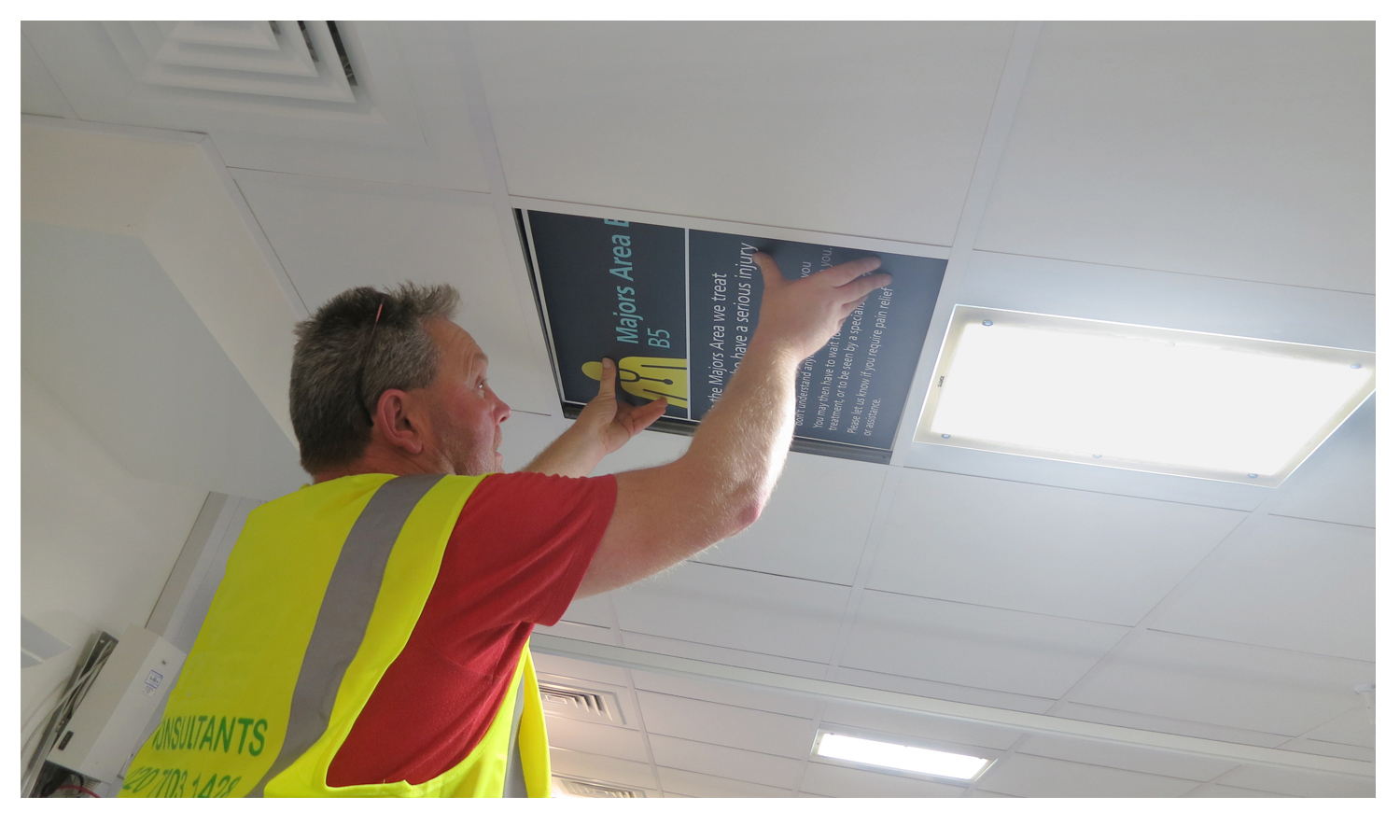  A team member installs a ceiling panel. 