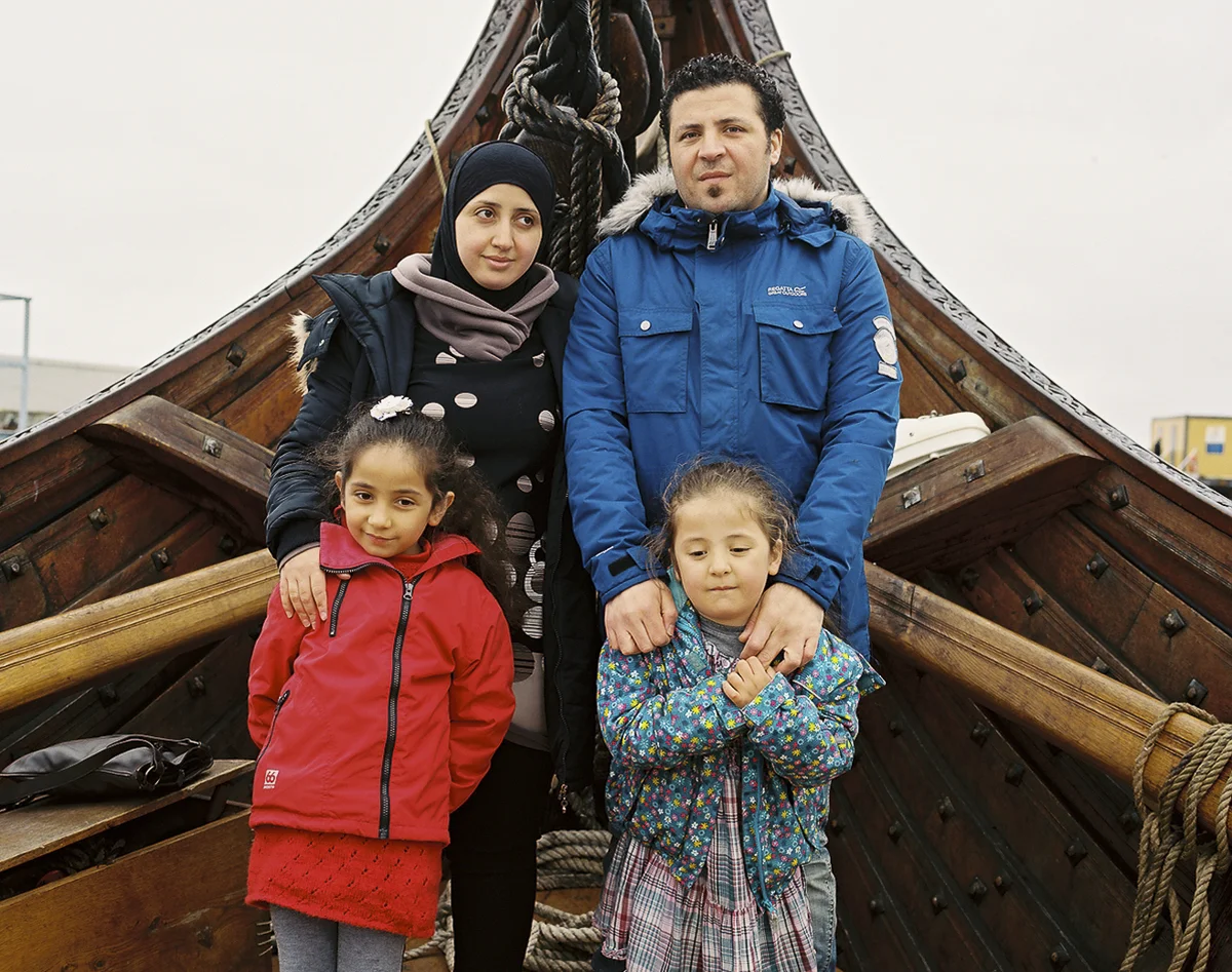 Maher (37), Hiba (32) and their two daughters on board the world's largest Viking ship docked briefly in Reykjavik harbor during its transatlantic sailing expedition. Maher (right) arrived in Iceland nearly two years ago from Syria as an asylum seeker after a challenging journey through Europe and surviving a fatal sinking of a boat of refugees headed for Greece. After living in a shelter for asylum seekers for nine months, Maher was given a positive answer to remain in Iceland. His wife Hiba and children arrived to join him in January of 2016 after he was granted family reunification.