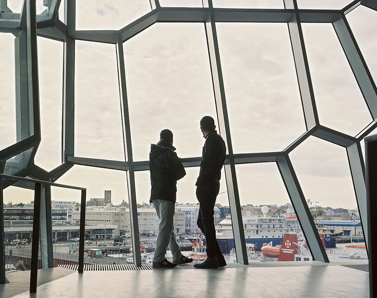 Two Iranian refugees inside the iconic Harpa concert hall overlooking downtown Reykjavik. Without family in Iceland, they have built a father and son like bond during their time in limbo as asylum seekers and continue to care for each other's needs.