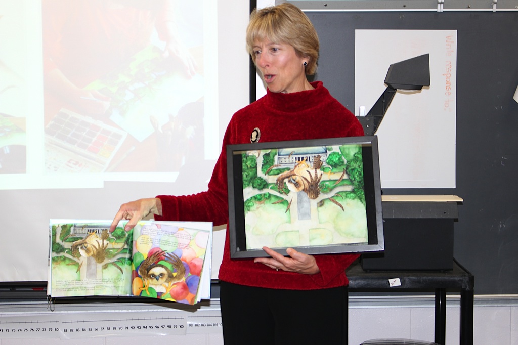 Susan Levine shows students one of the original paintings from Packard Takes Flight