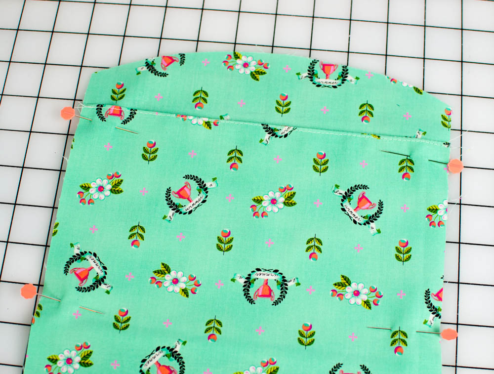 Make a pleat by placing the topstitched edge about 1'' below the closest curved edge. Pin the sides.