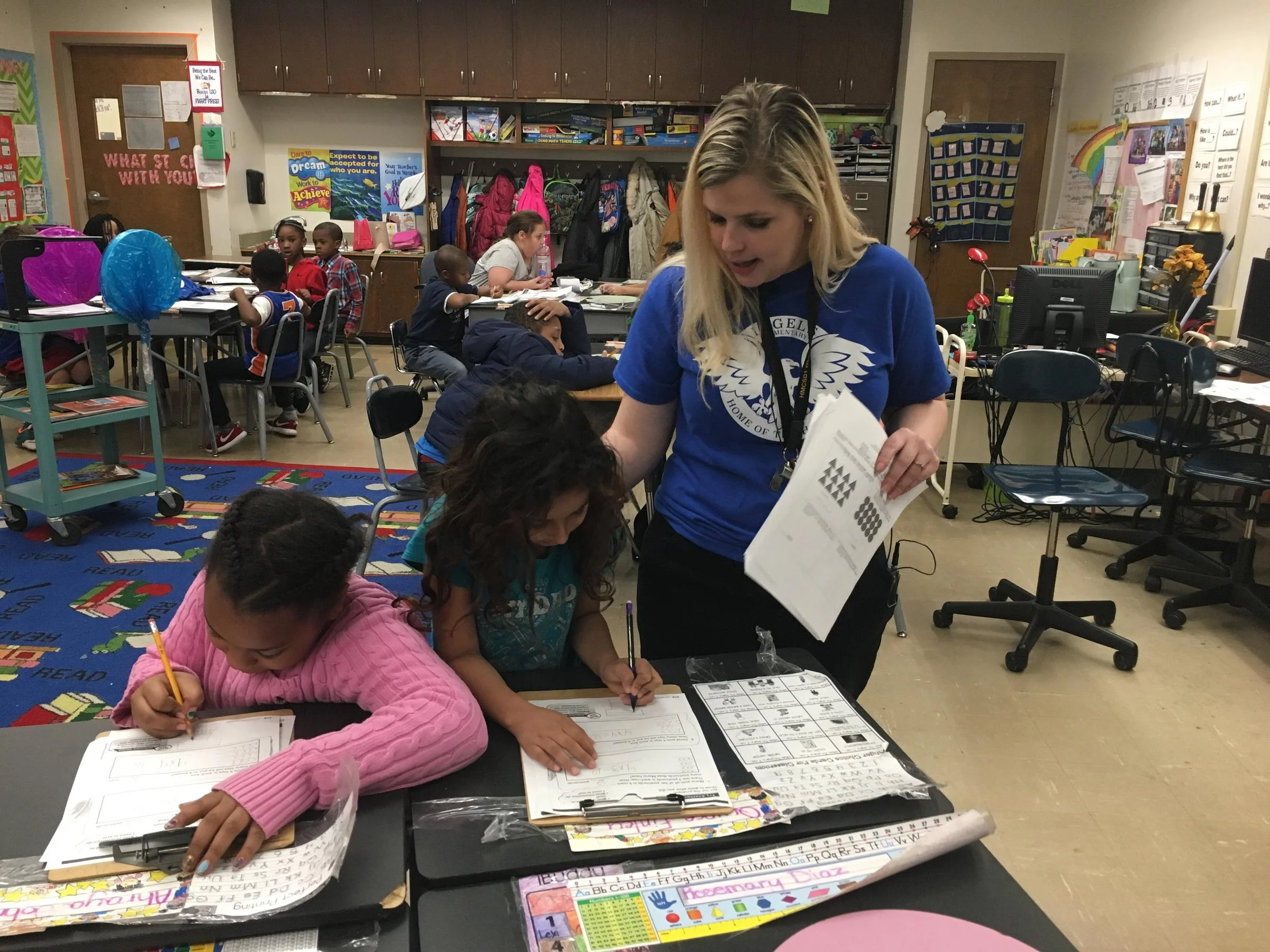 Second grade teacher Aubrey Paine helps students Ahraya and Rosemary with an assignment. ELLE MOXLEY / KCUR 89.3