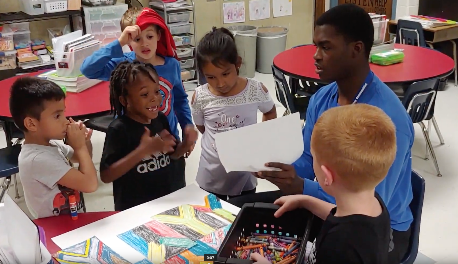 Children work on a collage based on South Africa’s flag with LINC staffer Zion Triplett at Grandview’s Meadowmere Elementary School.