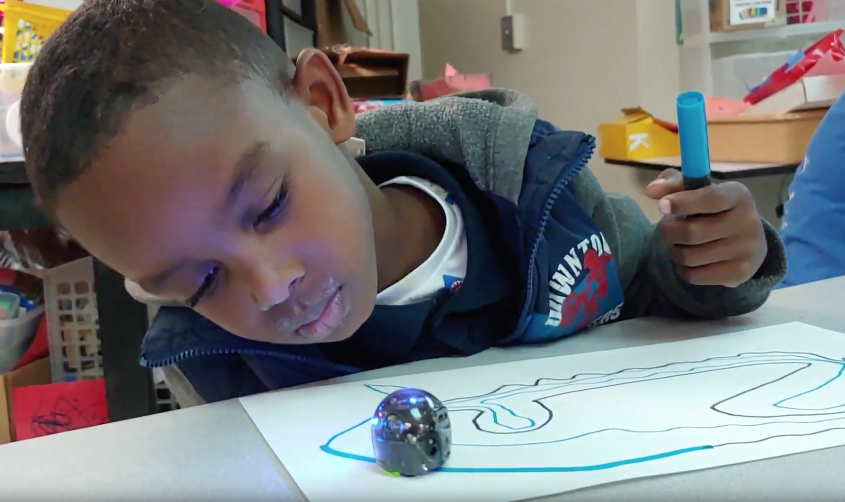 Indian Creek kindergartner Roy “RJ” Gonzalez Jr. watches a color-sensitive “Ozobot” light up as it traces his drawing in a visiting STEM program by Urban TEC.