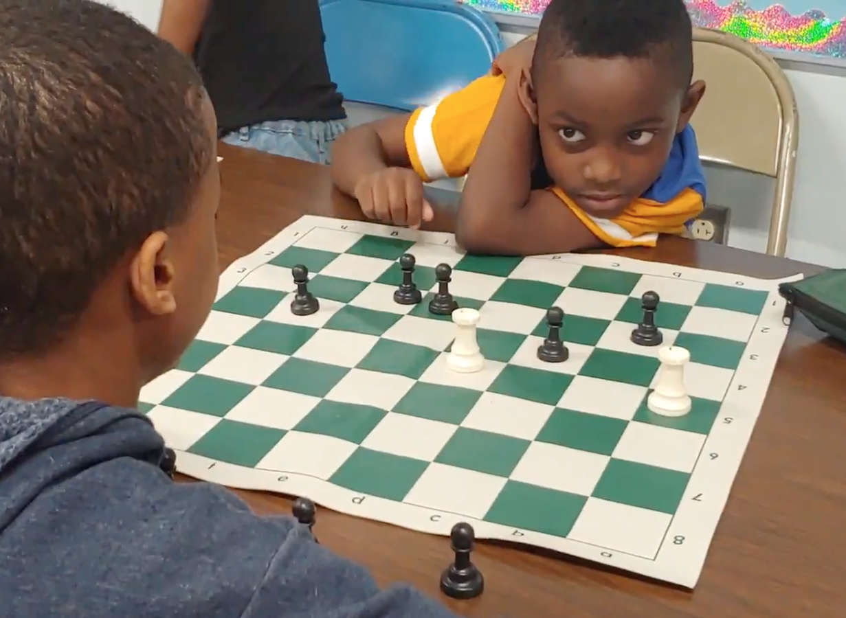 Braydon Allen, right, a second grader at Millennium at Santa Fe Elementary in Hickman Mills, watches for the next move by fifth-grader Peyten Thomas in a chess exercise called Rooks vs. Pawns.