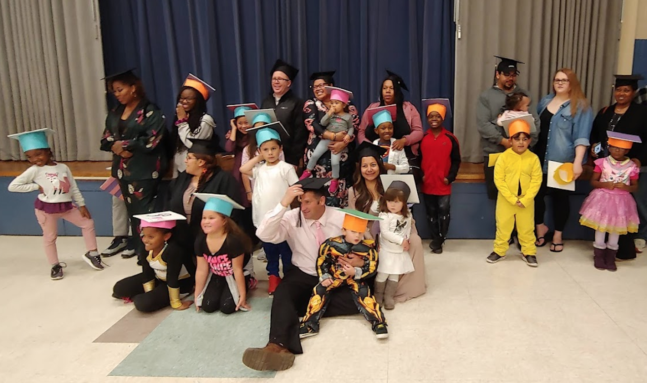 Seven graduating families pose for a group picture as LINC’s eight-week Families and Schools Together (FAST) program with the Fort Osage School District came to a close Oct. 22.