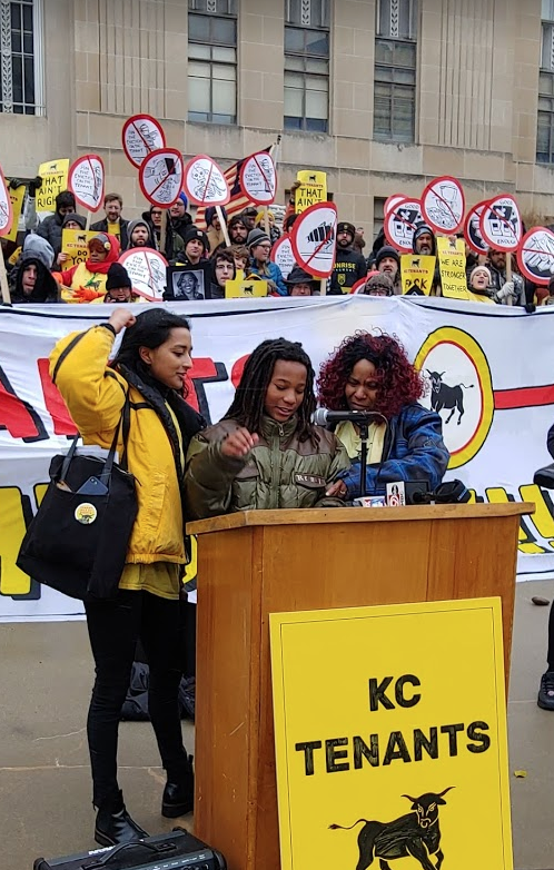 KC Tenants’ Tara Rhaguveer, left, and Tiana Caldwell, right, stand alongside Caldwell’s son, A.J. as he testifies at a rally at City Hall Oct. 30.