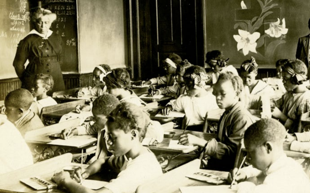 Principal Anna H. Jones (standing, left) leads a class at Douglass School in Kansas City, circa 1911. Photo: The Black Archives of Mid-America.