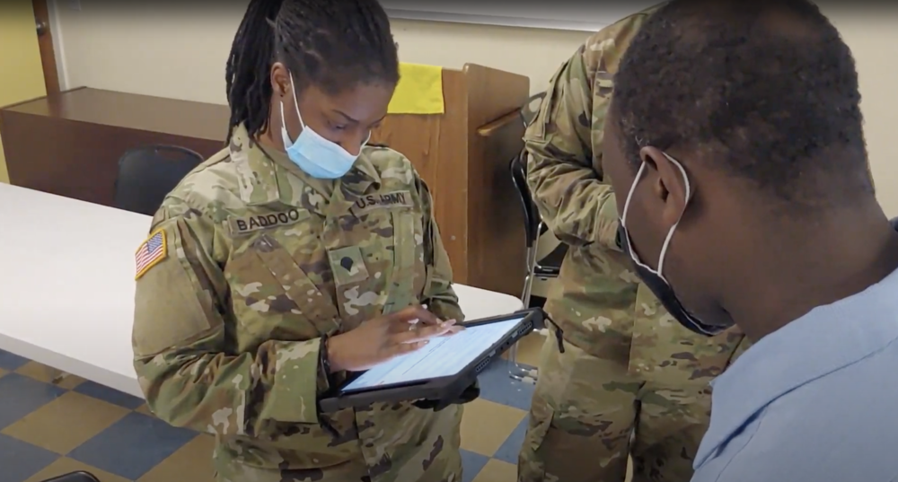 Missouri Army National Guard Specialist Crystal Baddoo prepares a client for vaccination in an Outbound team’s visit to Guinotte Manor housing community in Kansas City.