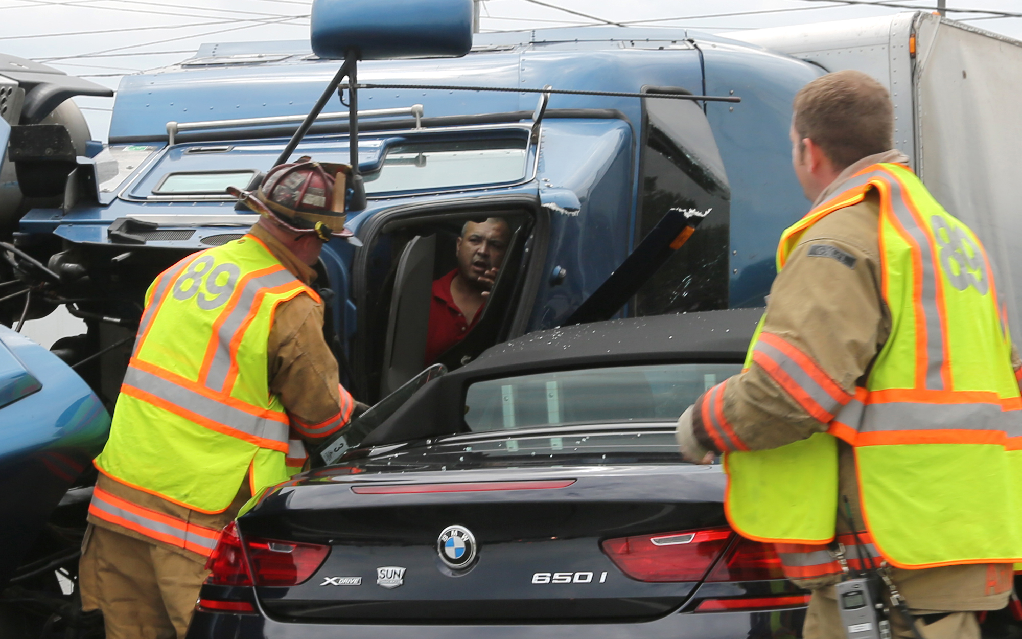 Freddie Conde, tractor-trailer driver signals firefighter from York Area United Fire & Rescue after his truck flipped on its side at the intersection of Haines Rd. and Mt. Rose Ave. in Springettsbury Township, Tuesday, July 15. 2014. Sonya Paclob - Daily Record / Sunday News