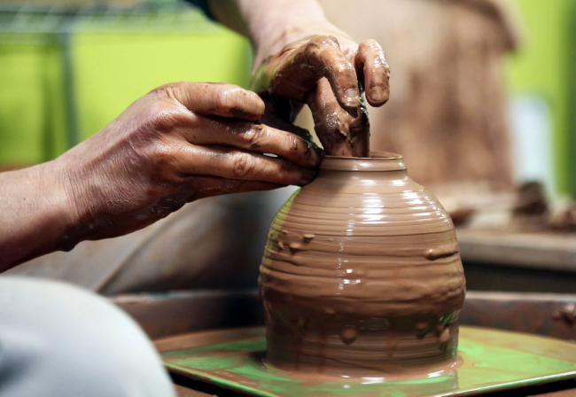 Kirsten Firlik, co-owner of Clay Path Studio, uses her fingers to guide the clay as it spins on a potter's wheel in York. The studio holds classes for beginners, advance and children. Photo by Sonya Paclob