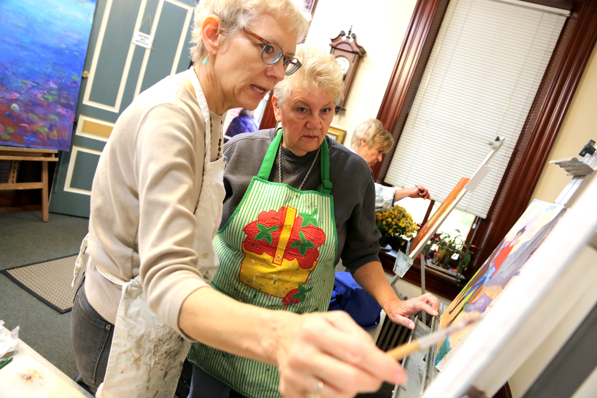 From left, painter and teacher Marion Stephenson helps with her Dover Township student Jewel Stough's painting in her home at 721 S. George St., York. Photo by Sonya Paclob