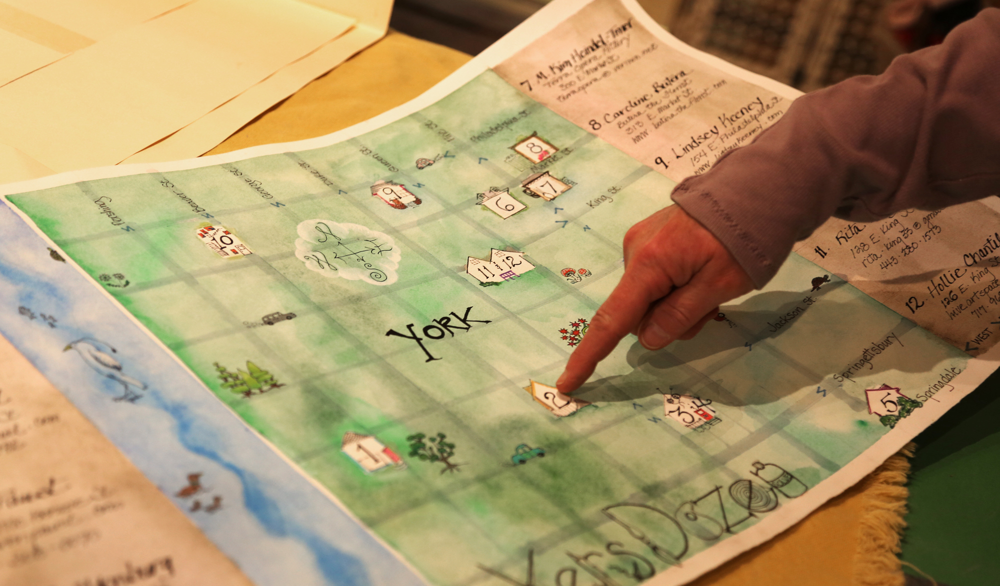 Kim Heindel-Toner, organizer of Artists' Studio Tour: Makers Dozen, points on the original map that was handmade and designed by other artists on the tour in her home in York. Those participating in the tour will be given the map, which marks locations of the artists' homes. Photo by Sonya Paclob