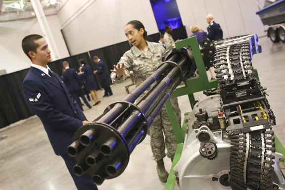 Senior Airman Chaleah Phillips talks to Airman First Class Gabriel Fox on the gun that goes into a F-15 at L angley Air Force Base 100th Anniversary Gala, Hampton, Saturday, Sept. 17, 2016. 