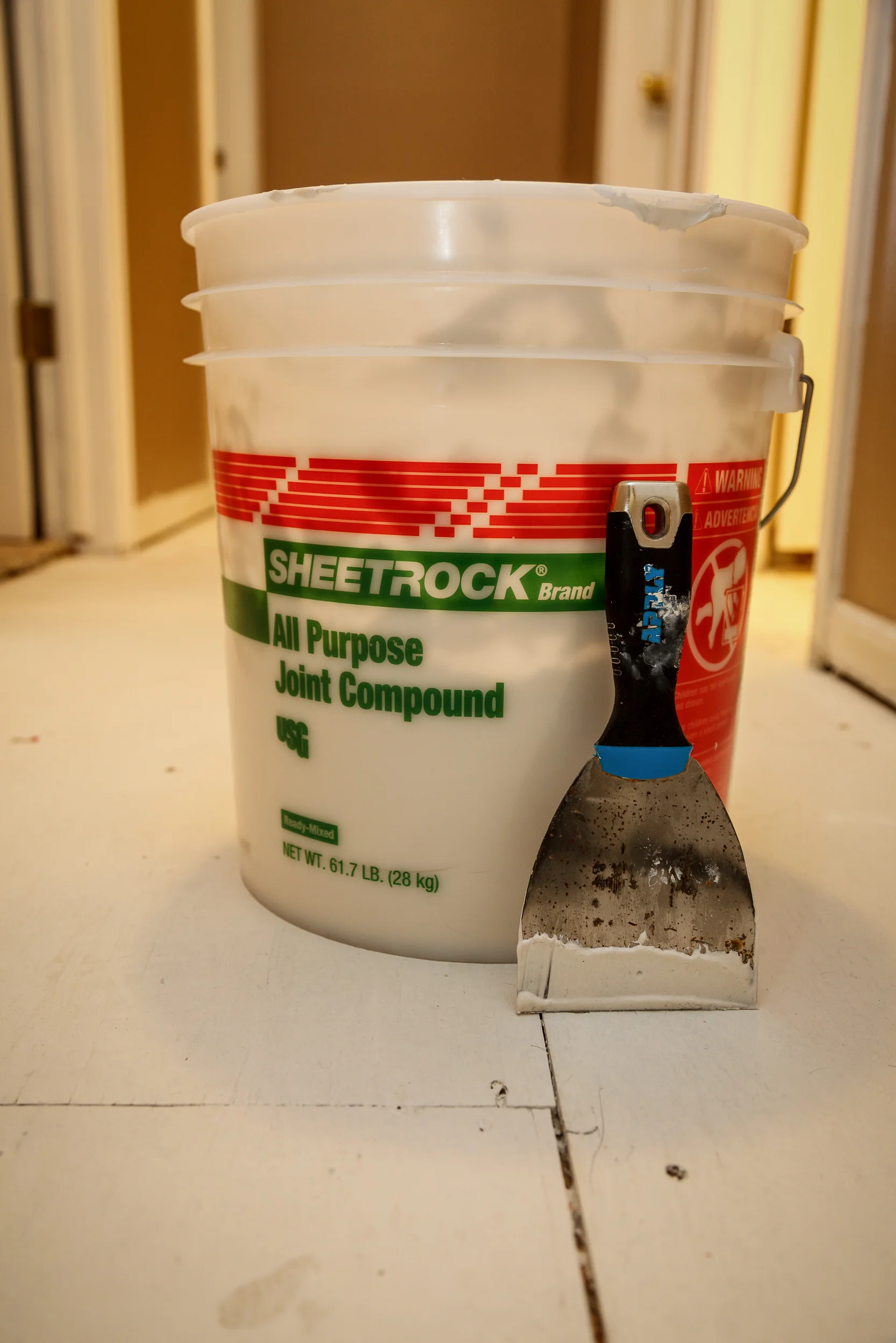 I filled all cracks, crevices, and nail holes with joint compound and smoothed. I probably should have used paintable caulk but this is what I had on hand and it was super easy. Because the finished floors were going to be medium-dark color with a lot of texture, it worked just fine in the end. If you are going for a lighter color with a solid color, I'd use something else. This took a couple of hours to dry before I could move on.