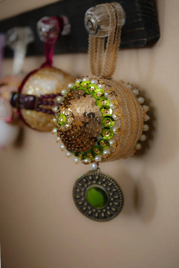Here is that ornament finished. After I secured the edges of the ribbon, I did the green sequin, gold sequin, pin combination all around, slightly overlapping them so the foam wouldn't show. Next I used a gold sequin ribbon. I started in the center and spiraled it out to the green, pinning in a few spots along the way. You can see the pins if you look closely. Next I , I used a gold sequin, green sequin, pearl, pin combo in the center of the gold ribboning. I outlined that with a gold sequin, pearl, pin combo. To finish it, I added the hanging jewel and the "hanger". When doing these, make sure to use a few extra pins or even a small nail for added security. 