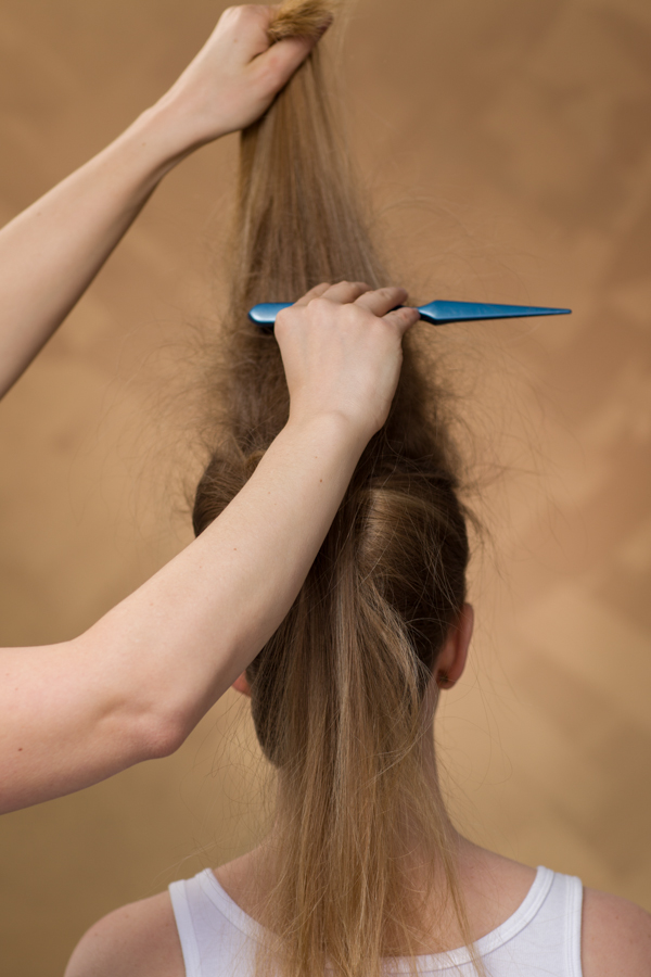 Backcomb the top section using the same technique. To create volume, be sure to elevate the hair straight up while backcombing. 