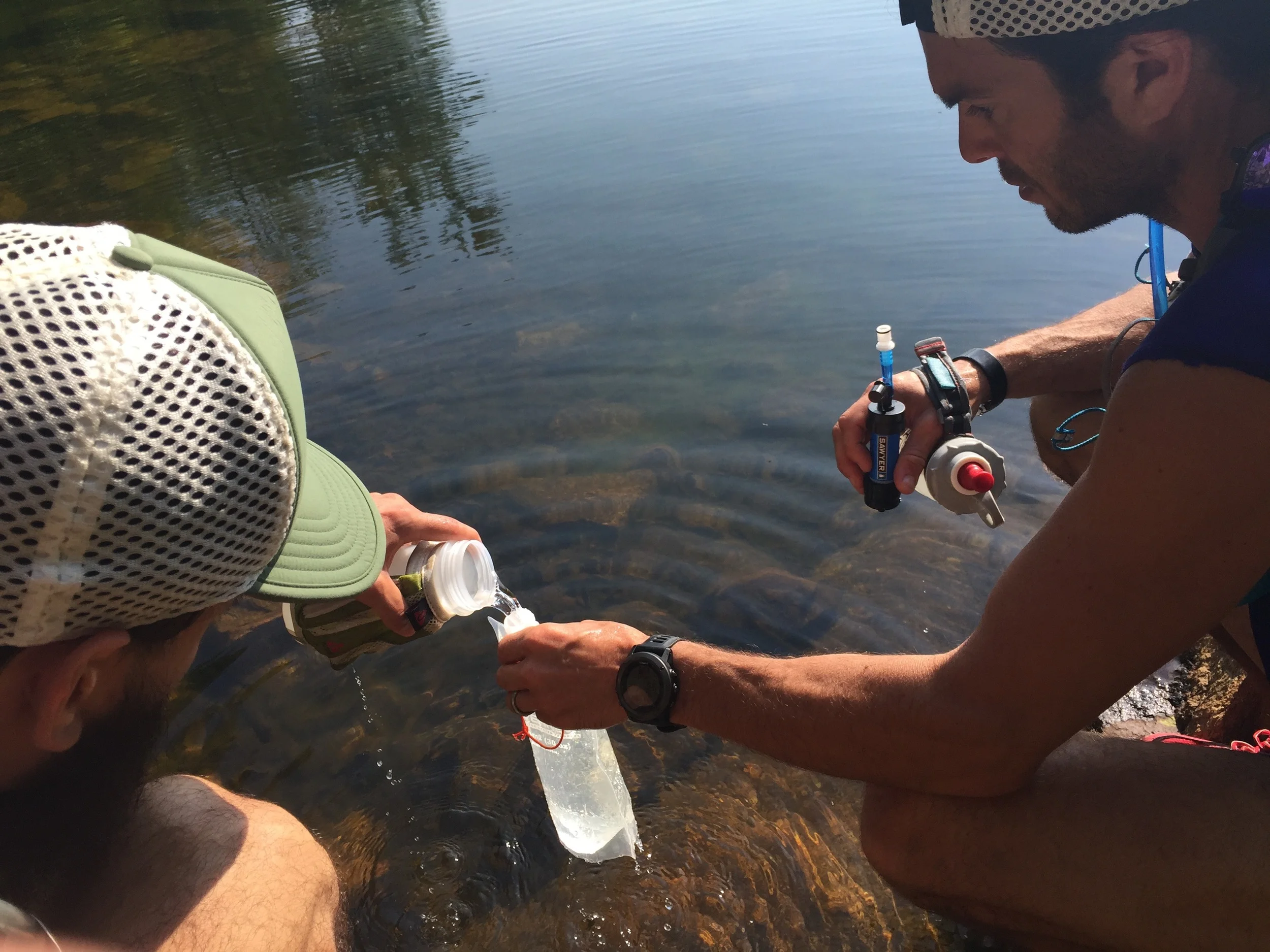 Jay Lemos and Julian Vicente filtering water at the Third Reservoir that is right on the trail.