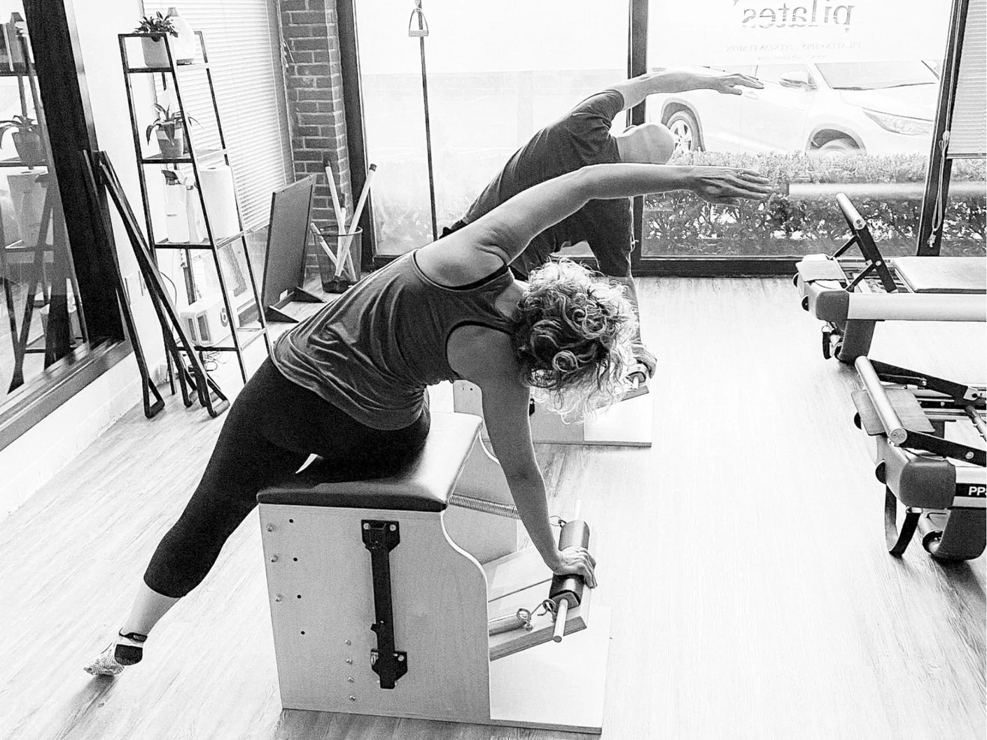 Two clients using the pilates chair to improve balance.