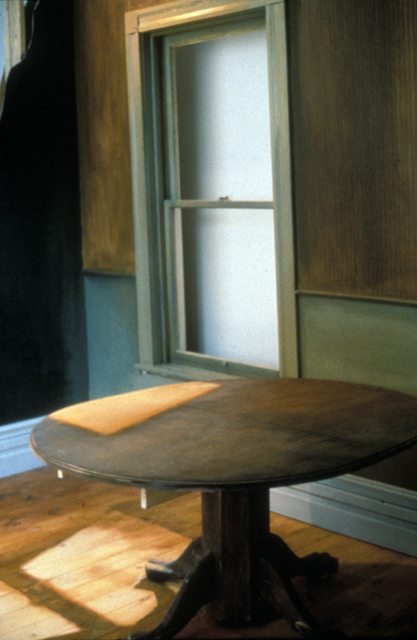 At first sight, "Sunlight on Table and Floor" appears to be an ordinary domestic interior, but on closer inspection we realize that the impression of light cast onto the table and floor is illusory. By sanding and painting the wooden surfaces, the artist has replicated the pattern of sunlight entering through a window, playing with light and shadow just as a painter would in a naturalistic work. The result is startling in its realism, yet we are made aware of the artifice and the gallery setting. The piece captures an ephemeral moment and demonstrates Favro's exploration and reproduction of objects and perceptual phenomena.(from the NGC website)