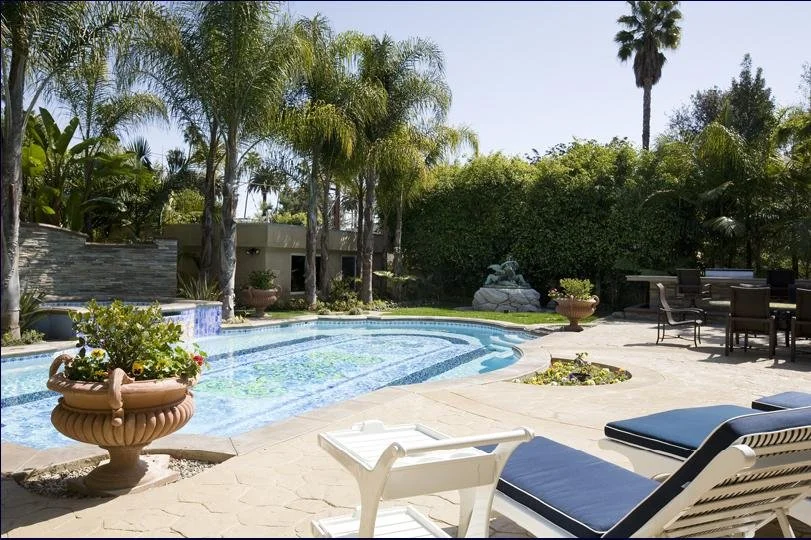 Once a fountain, Cherubs in Bronze overlook the hand-painted tile by Italian artist in the swimming pool. Lave ashes made into ovel dining table top, painted by Italian artisans complete the grandeur to this very well appointed back yard.