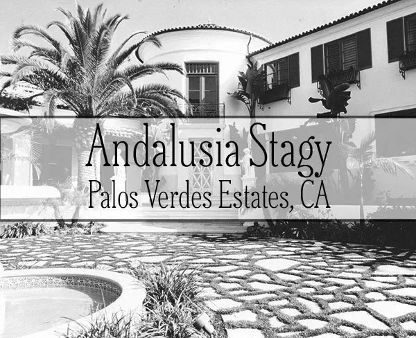 Nighttime view of a large white house with balconies and a fountain in the front yard, with the text "Andalusia Theatrical" Palos Verdes Estates."