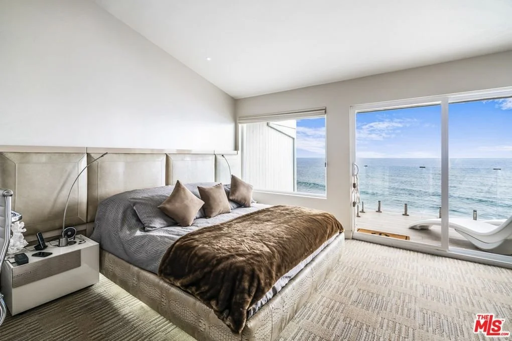 Embossed leather adorns the platform bed, matched with lacquered bedside tables. 
