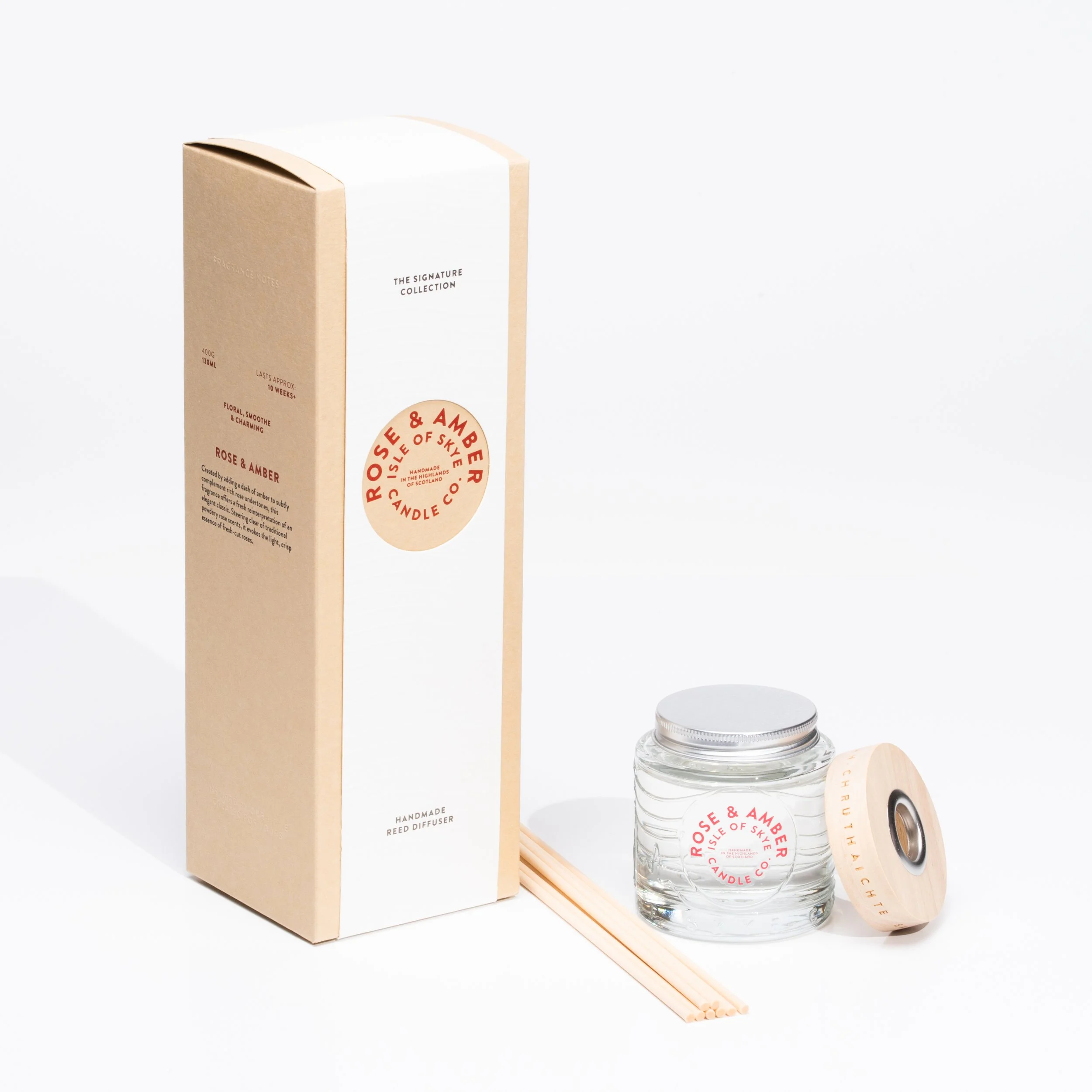A boxed reed diffuser with a glass jar, a wooden lid, and reed sticks, featuring a label for 'Rose & Amber' scent from the Isle of Skye Candle Co.