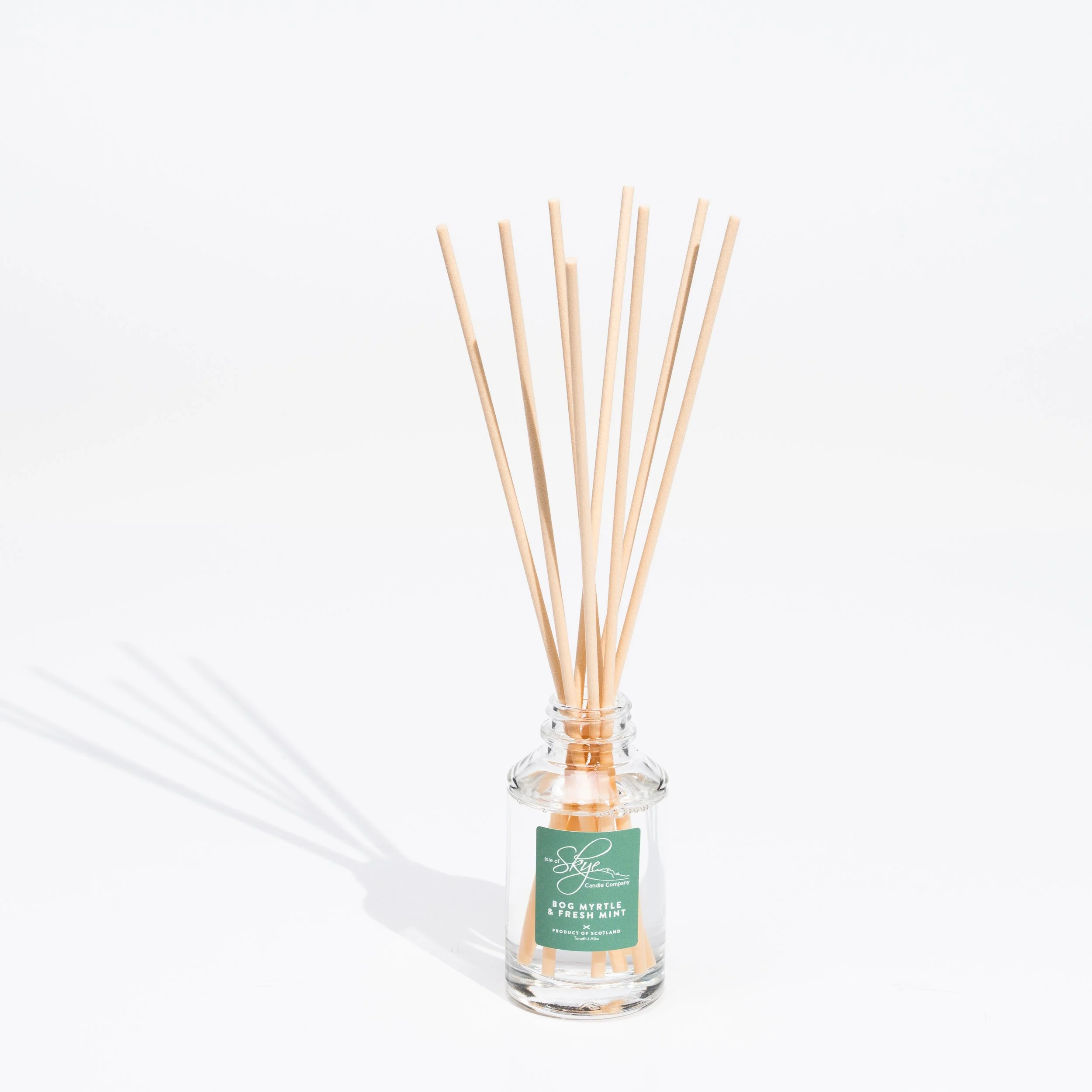 Glass jar containing reed diffuser sticks, labeled 'Skyne Candle Company, Bog Myrtle & Fresh Mint' on a white background.