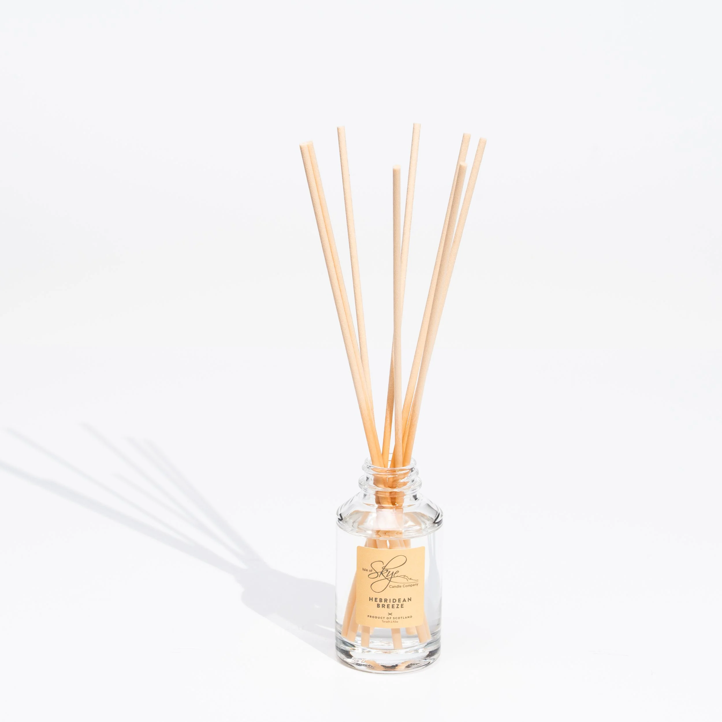 A glass diffuser bottle with wooden sticks labeled 'Hebridean Breeze' against a white background.