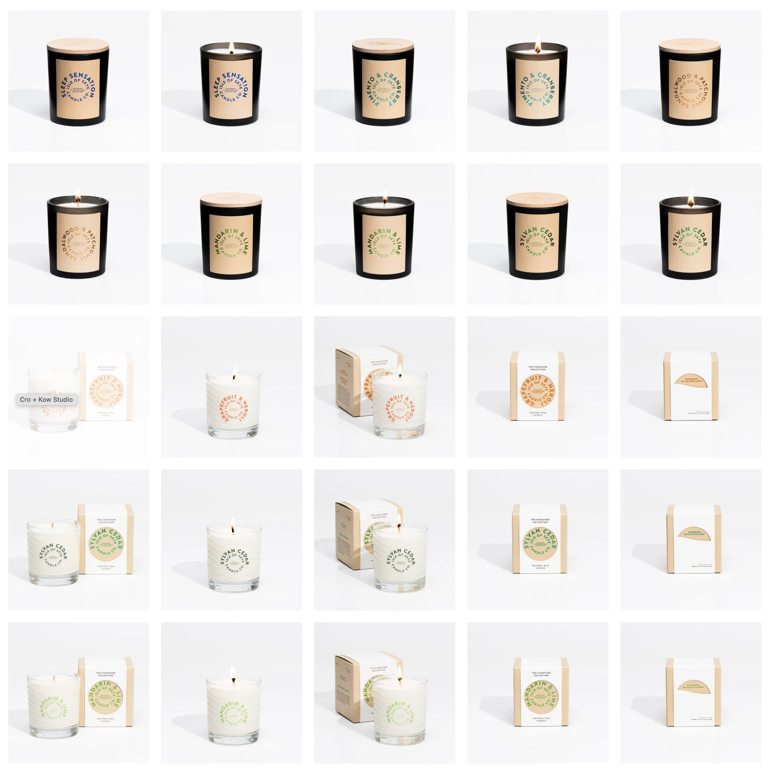 Collection of candles with black or clear glass jars, some lit and some unlit, featuring labels with different color schemes and packaging variations.