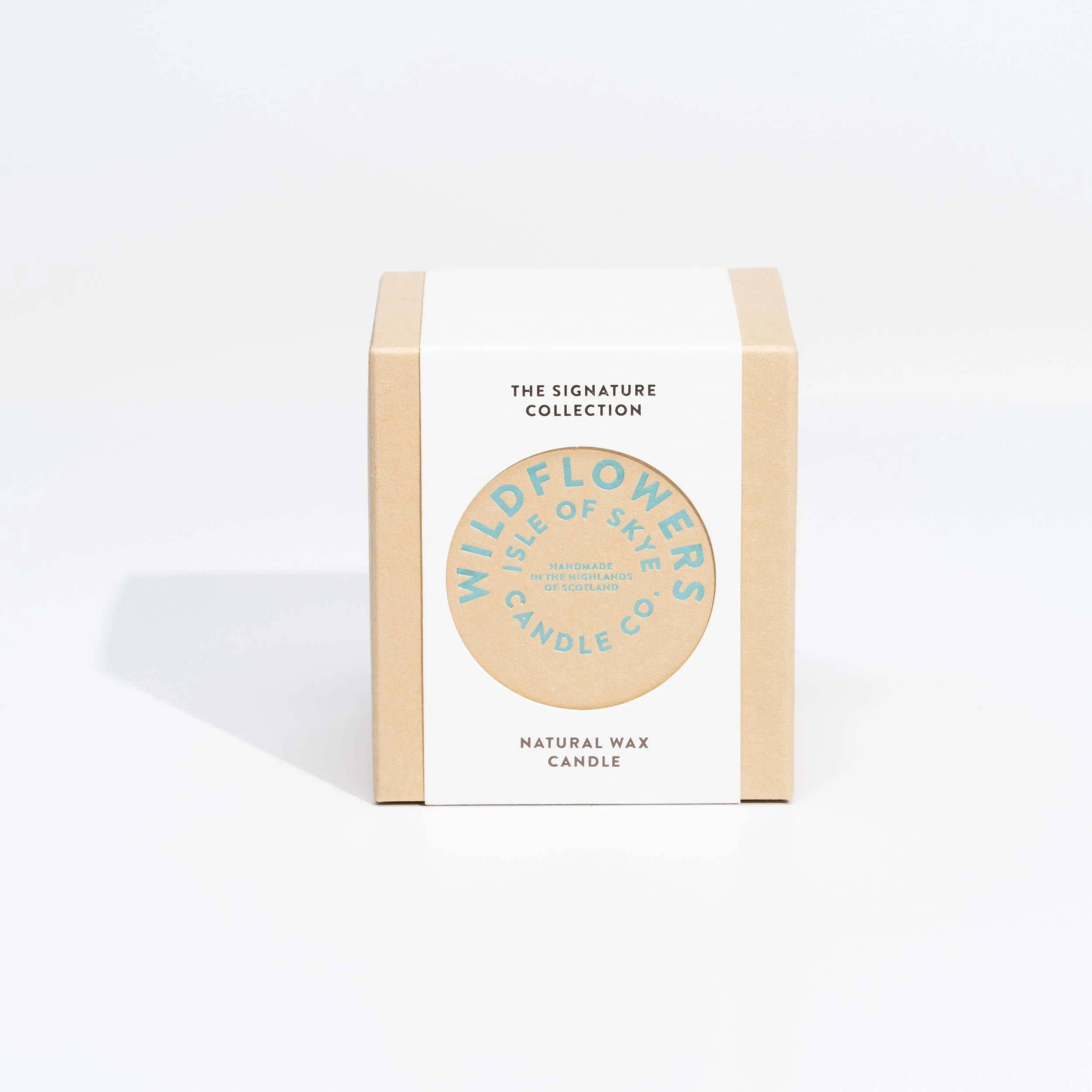 A beige and white box of Wildflowers Candle Co. natural wax candle with a label featuring light blue text on a beige circle and a white background.
