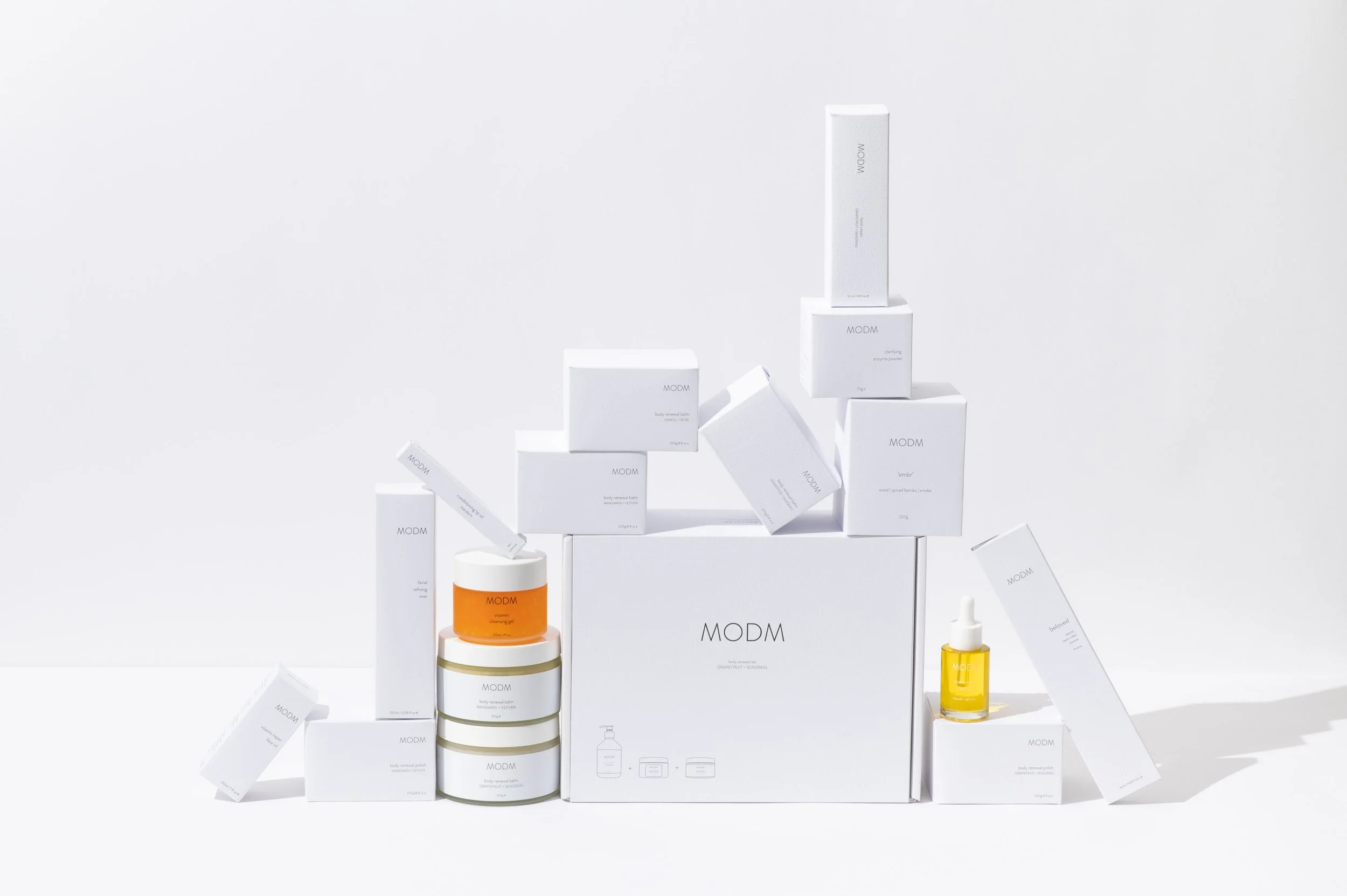 Collection of skincare products including boxes, jars, and a dropper bottle arranged on a white surface with a white background.