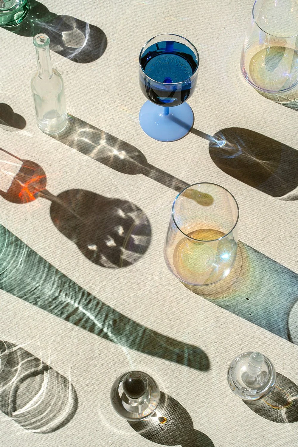 Glassware styled product photography- glasses and bottles - photographed with hard light from above