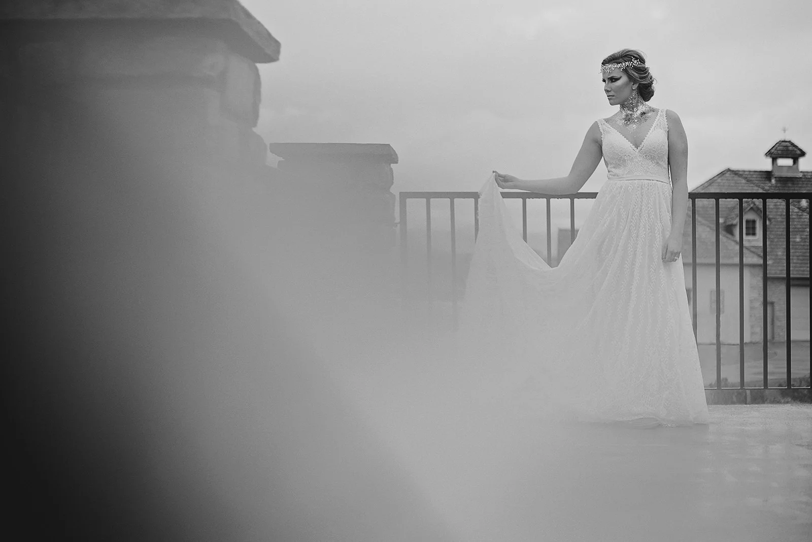 Black and white of bride holding dress on patio