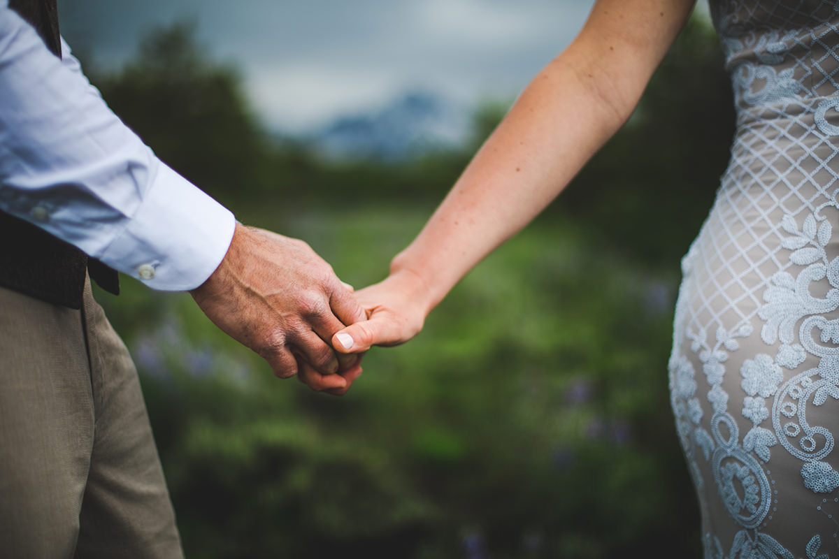 Closeup of bride and groom holding hands