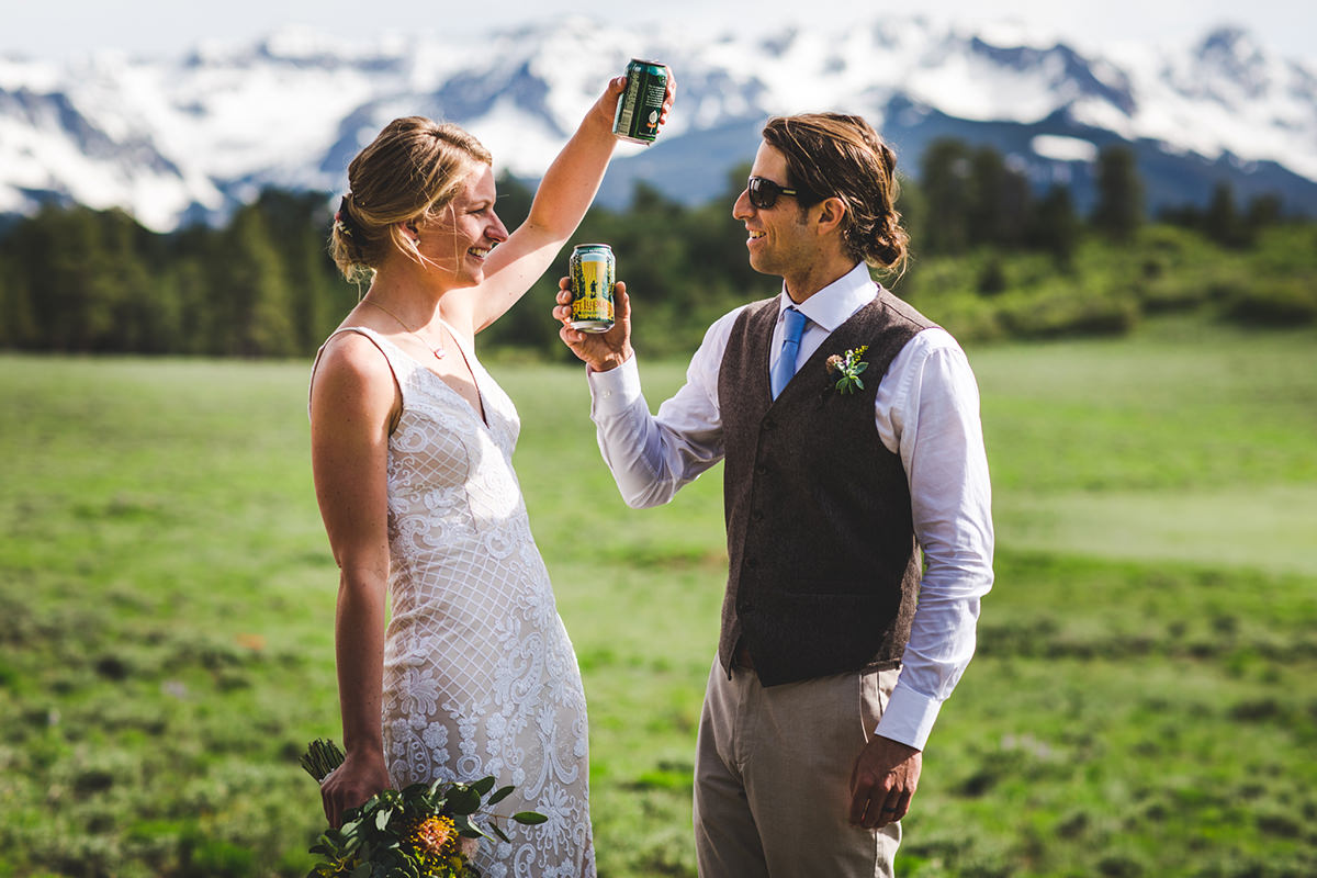 Couple clinking their beers after their wedding ceremony
