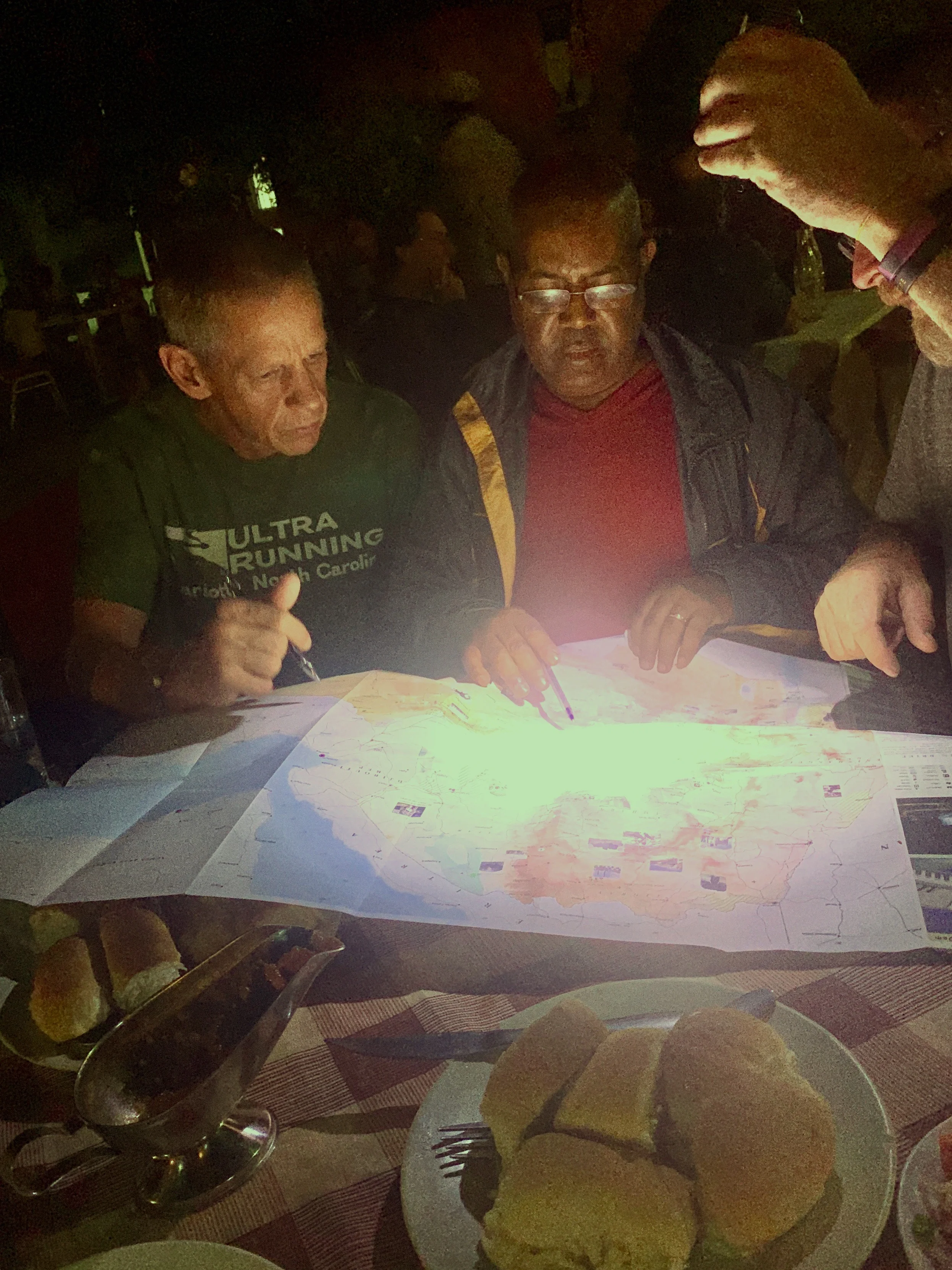 One of many late night map sessions with my team. Solomon is giving us his thoughts on the route, based on his local expertise.