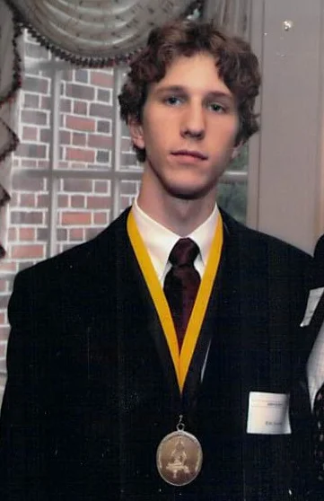 Kristopher accepting his Woodrow Wilson Undergraduate Research Fellowship shortly before graduating John Hopkins in 2003