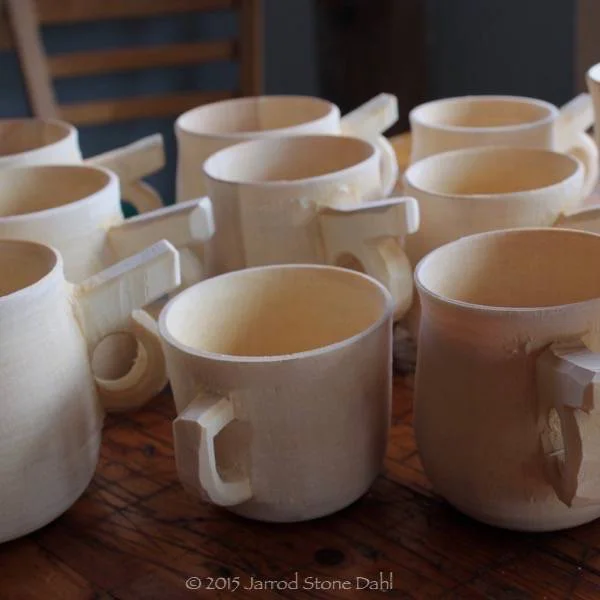 a batch or handled mugs ready for the oil/wax bath. These can only be turned on a pole lathe.